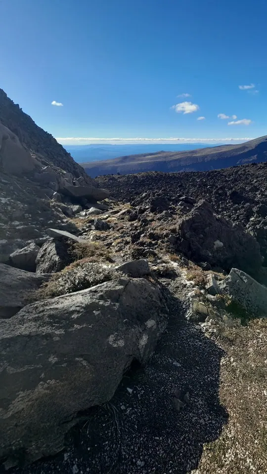 Following the faint ground trail beneath the cliffs of Pukekaikiore