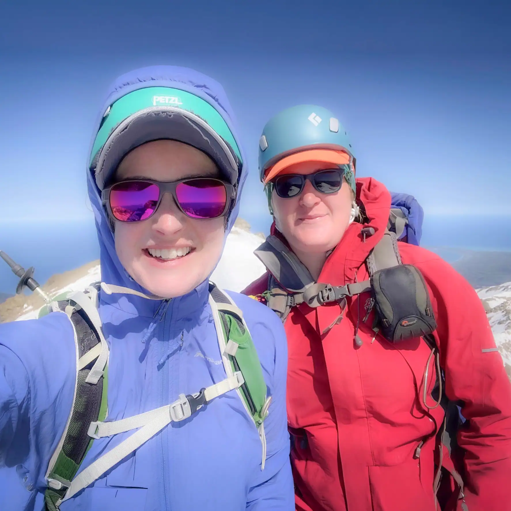 Two hikers stand on the summit of Te Ao Whekere after a long climb from sea level to 2,590m