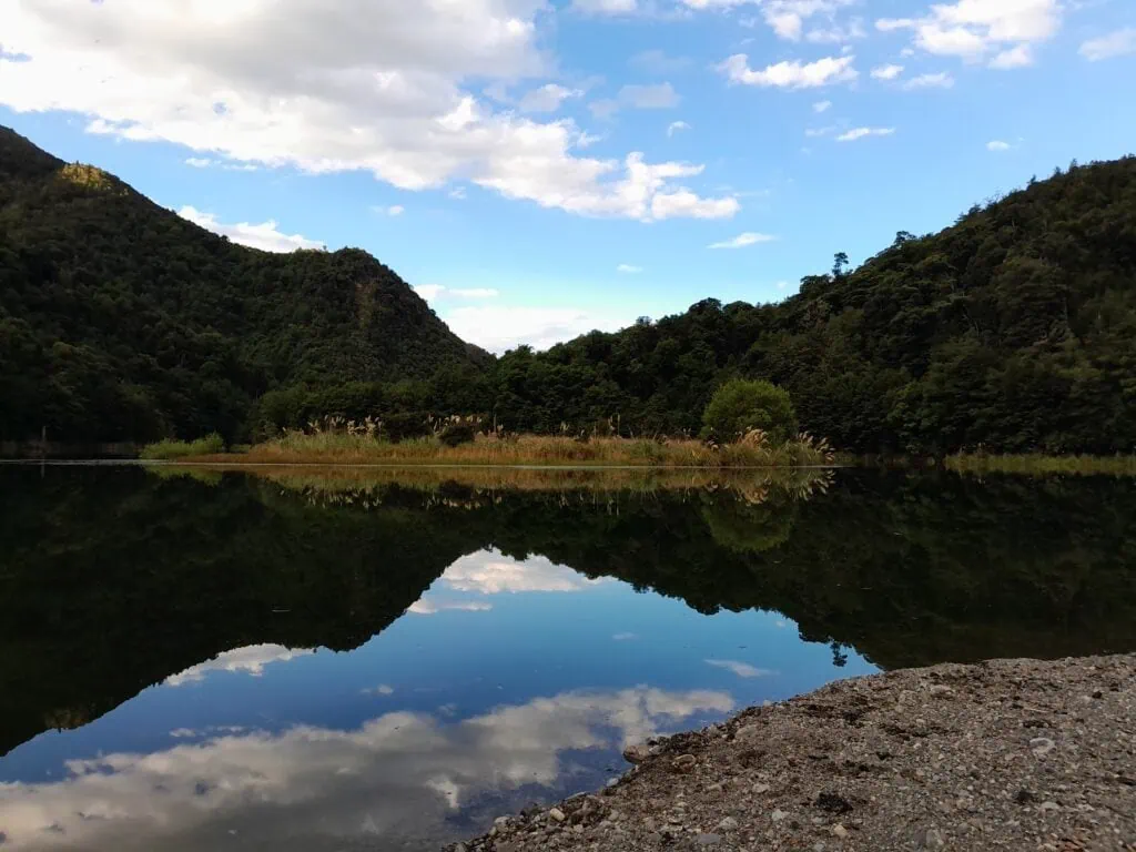 Stunning Reflections in a lake called Lake Alexander surrounded by trees with a blue sky above