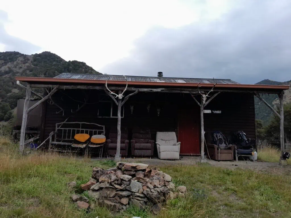 A building known as Tummil Ridge Resort with antlers on the front porch and couches with a fireplace in front of it