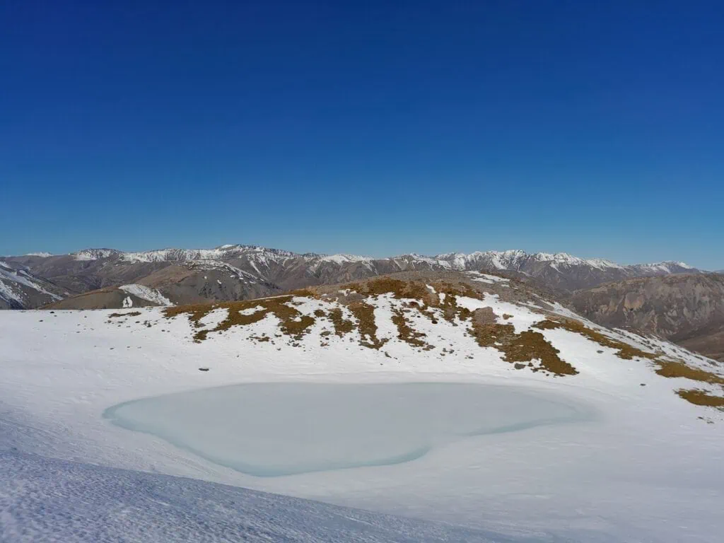 A snowy covered frozen azure tarn on Mt Princess on the climb to Princess Bath in St James Conservation Area