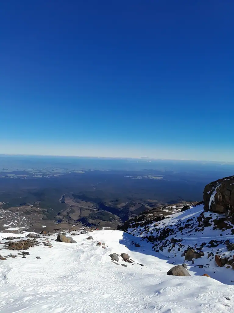 Descending down a snow covered slope in crampons from Te Ātaahua on Mt Ruapehu in Tongariro National Park