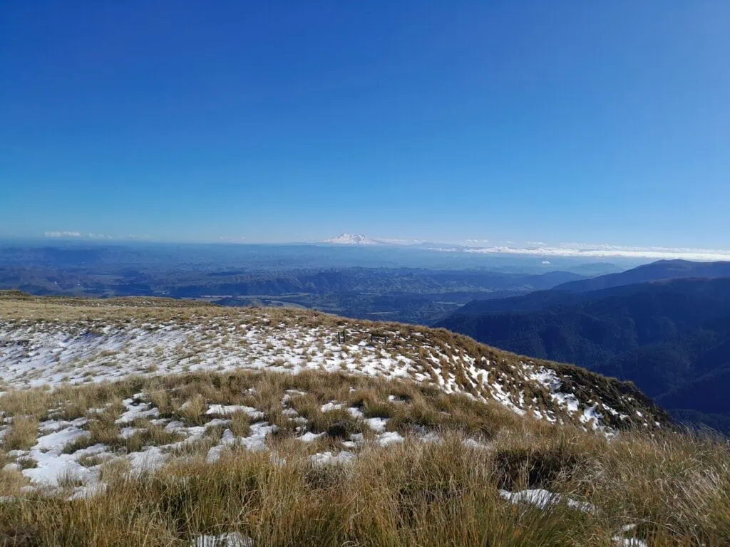 A snow-covered southern side of Mt Ruapehu from the Pourangaki Hut junction amongst snow covered tussock in the Ruahine Range