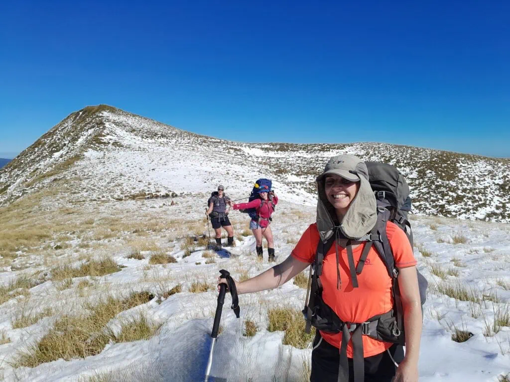 A tramping group plugging steps through snow on the tussock ridgeline after Maungamahue in the Ruahine Range.