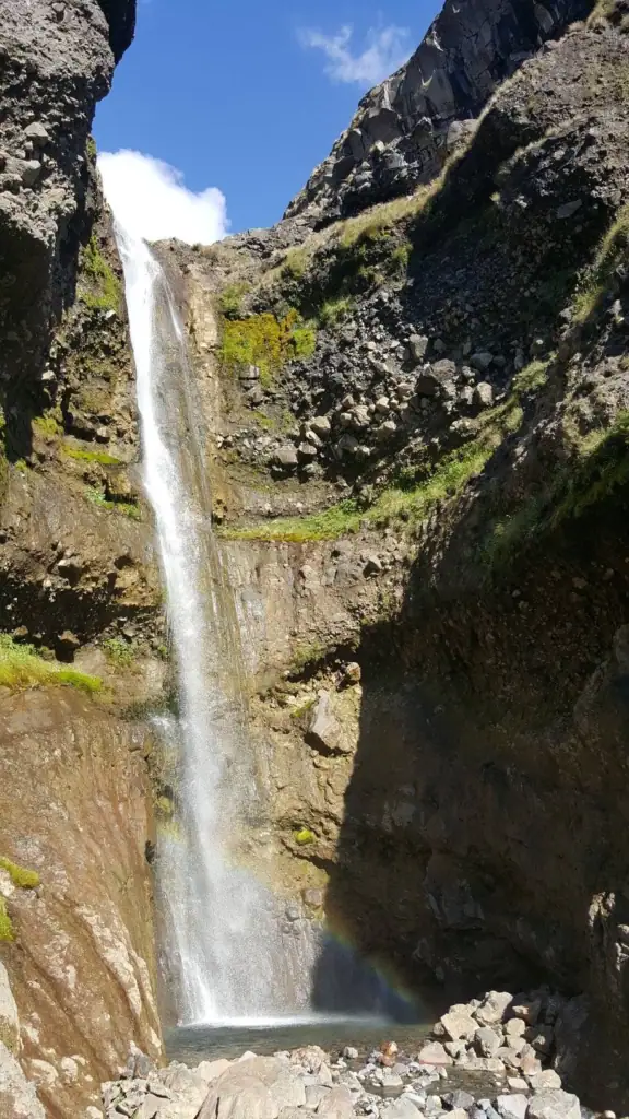 The hidden 43-meter Whakapapaiti Waterfall off the Whakapapaiti track with the cascading waterfall creating a rainbow