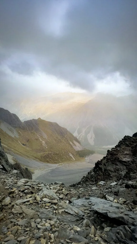 Moody mountain view from Gunsight Pass looking down into the misty South Temple Valley over a scree slope, Ruataniwha Conservation Park, Canterbury, NZ