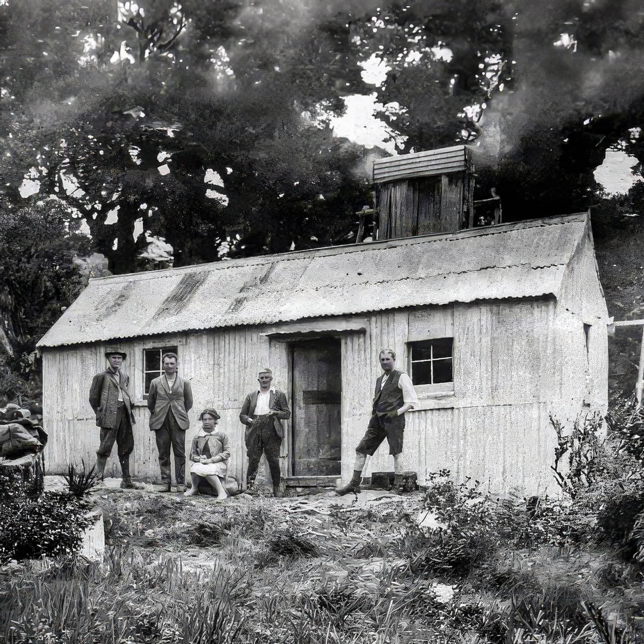The first dedicated tramping hut built in the Tararua Range - Alpha Hut No 1 with trampers dressed in 1930s attire of tweed jackets for men and dresses for women.