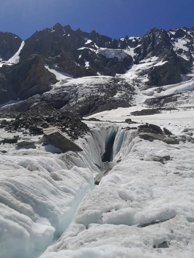 A close-up shot of a deep, dramatic slot crevasse opening up in the white ice of the Ashburton Glacier, Arrowsmith Range, Hakatere Conservation Park, Canterbury