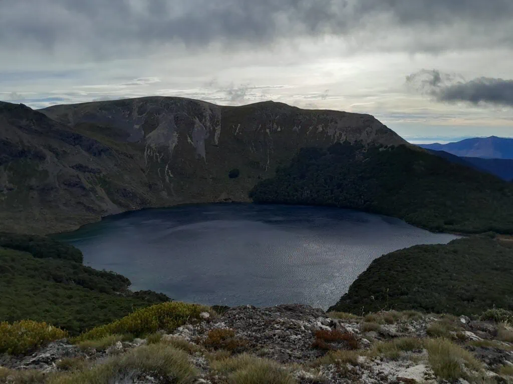 Wide alpine vista from the summit of Mount Lockett looking down over Lake Lockett and surrounding mountain ridges.
