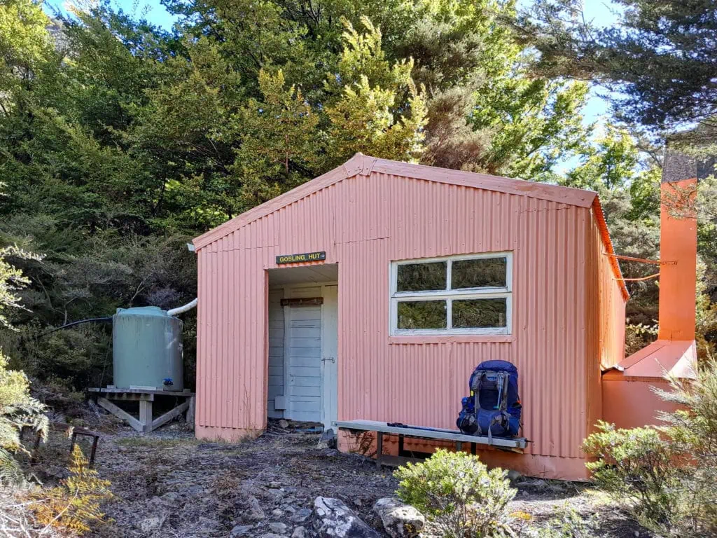 Gosling Hut nestled against the bush on a terrace above the Gosling River
