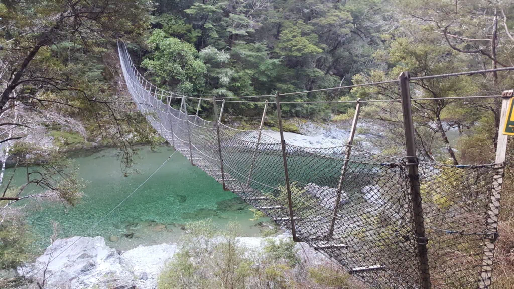DOC swing bridge crossing the crystal-clear Pelorus River / Te Hoiere near Roebuck Hut in Mount Richmond Forest Park on the Pelorus Track.