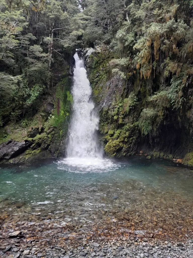 Powerful Travers Falls plunging into a clear turquoise pool in Nelson Lakes National Park.