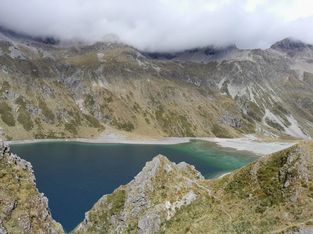 Elevated view showing the dramatic colour transition from deep blue to shallow turquoise at Lake Constance / Rotopōhueroa on the Waiau Pass Route, Nelson Lakes National Park