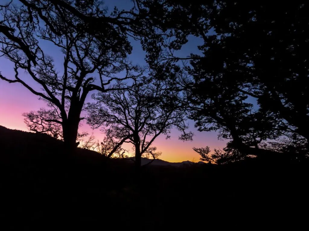 Pink and orange sunset over mountain ridges during the climb to Turkeys Nest Bivvy